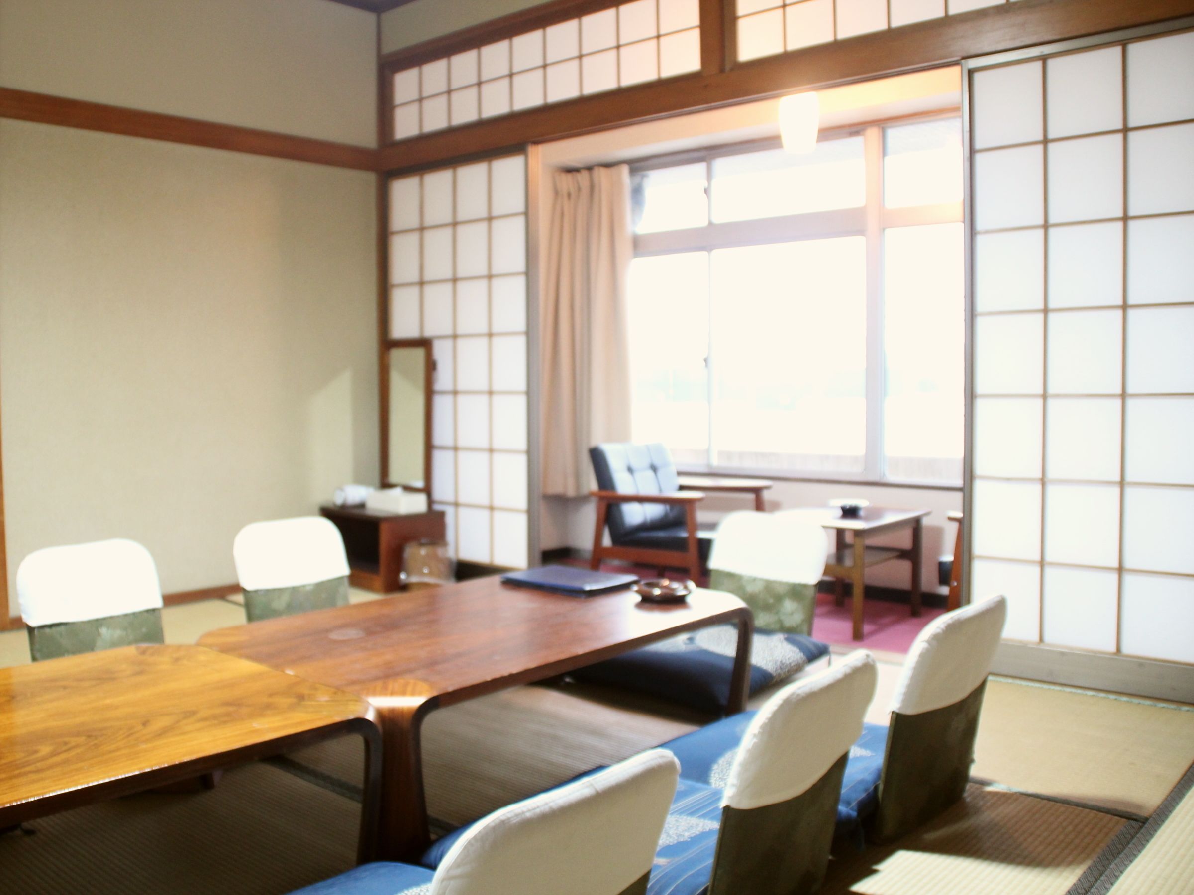 Una sala de reuniones tradicional al estilo japonés, con esteras de tatami, mesas bajas y puertas correderas shoji.