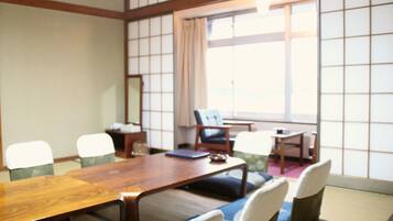 Una sala de reuniones tradicional al estilo japonés, con esteras de tatami, mesas bajas y puertas correderas shoji.