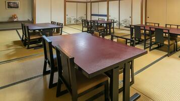 A traditional Japanese-style room with tatami flooring, wooden tables, and sliding doors.