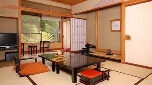 A traditional Japanese-style room with tatami flooring, a low table, and sliding doors. - Saneatsu No Yado Izumiso (Shizuoka)