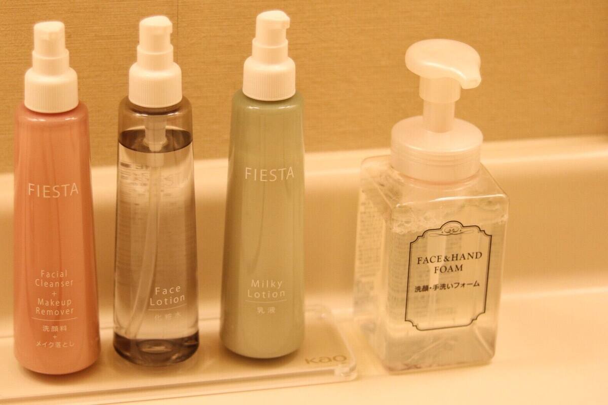 Cuatro productos de cuidado de la piel sobre una encimera de baño.