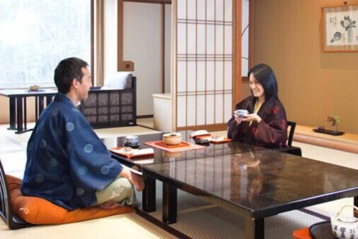 Una habitación japonesa tradicional con suelo de tatami, una mesita baja y una puerta corredera.