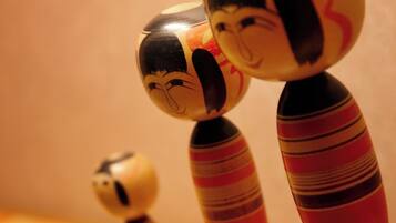 Three wooden figures with painted faces and striped bodies.