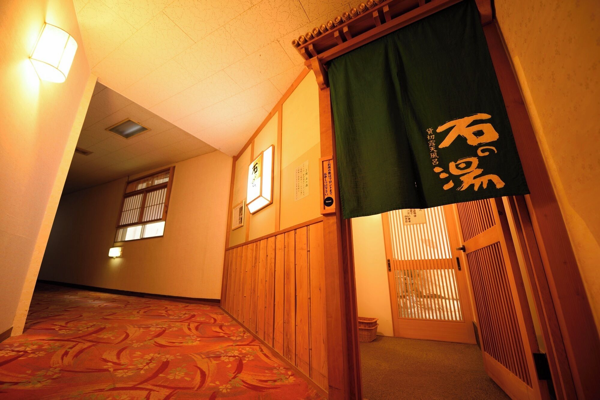 A traditional Japanese interior with tatami flooring, sliding doors, and a sign with Japanese characters.