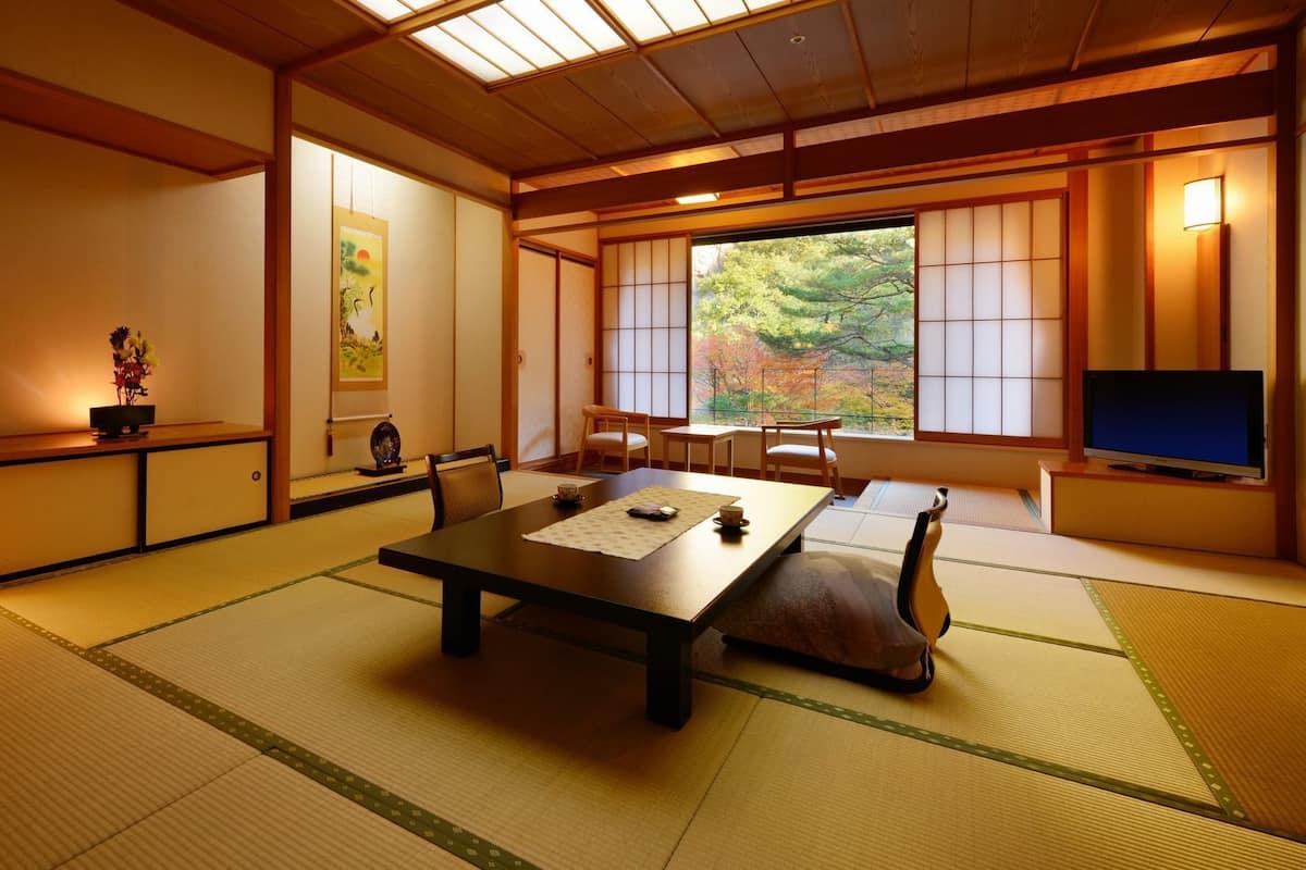 A traditional Japanese room with tatami flooring, a low table, and sliding doors.