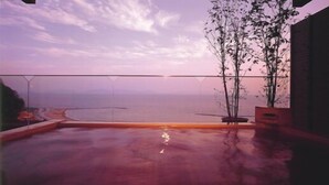 A rooftop pool with a view of the ocean and a distant shoreline. - Nishiura Grand Hotel Kikkei (Gamagori)