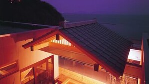 A modern house with a wooden deck and large windows. - Nishiura Grand Hotel Kikkei (Gamagori)