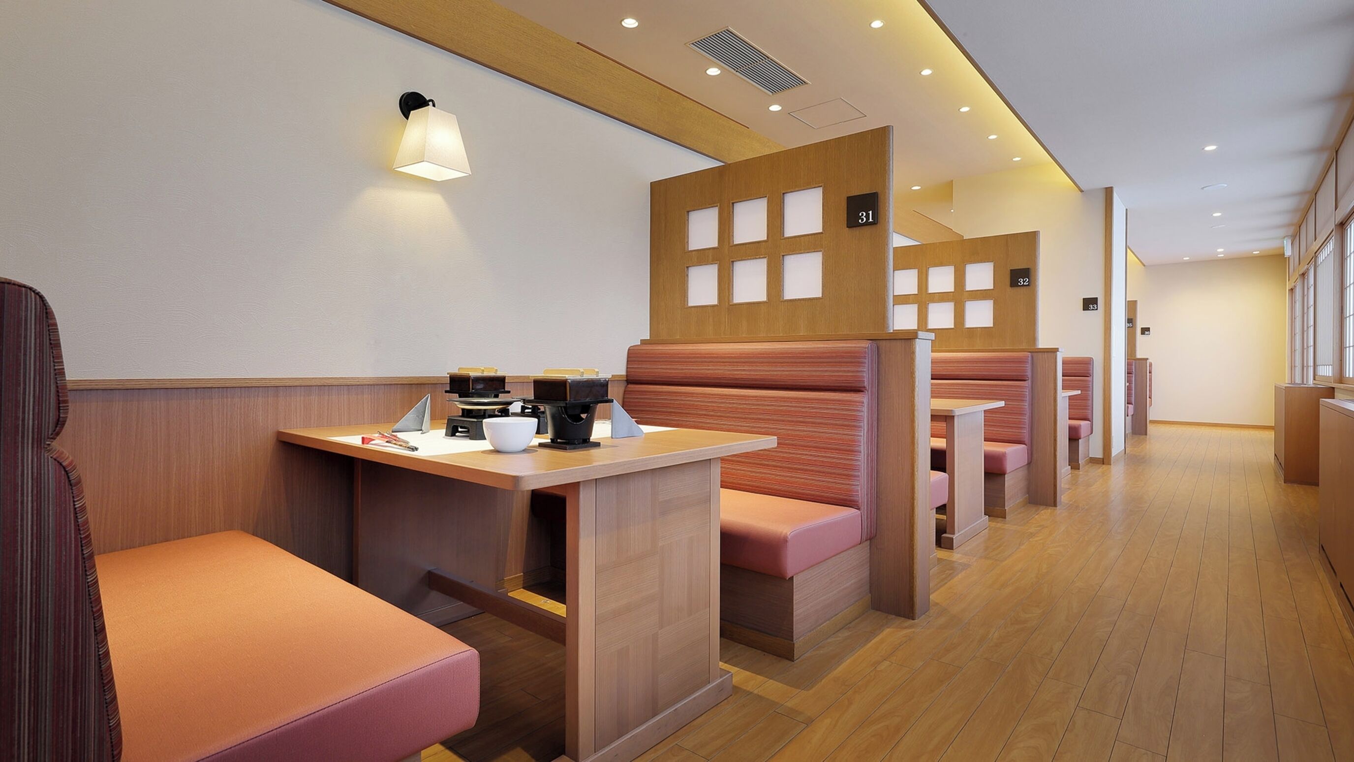 Ein Restaurantinneres mit Sitzecken, Holzvertäfelung und mehreren Tischen.