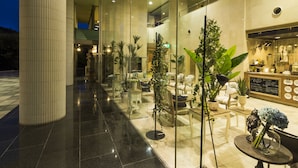 A modern hotel lobby with a glass partition, seating area, and a reception desk. - Hotel AreaOne Hiroshima Wing (Higashihiroshima)
