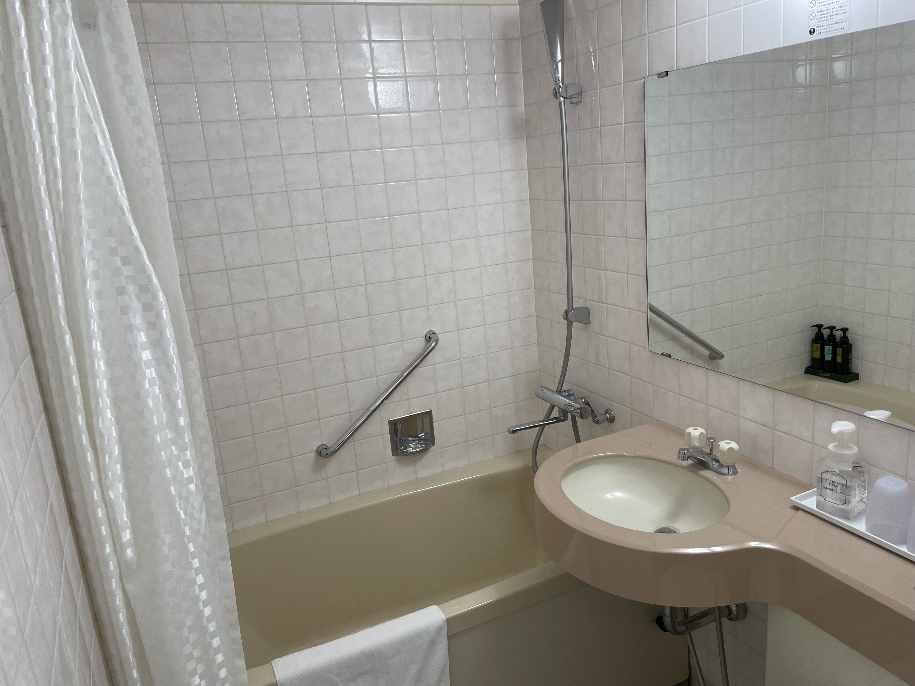 A bathroom with a bathtub, a sink, a mirror, and a shower.
