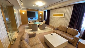 A modern hotel room with a living area featuring sofas, a coffee table, and a glass partition. - Tokyo Dai-ichi Hotel Tsuruoka (Tsuruoka)