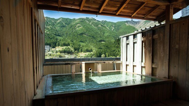 A wooden hot tub with a view of a mountain landscape. - Gero Onsen Okudaya Happoen (Gero)