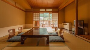 A traditional Japanese room with tatami flooring, a low wooden table, and sliding doors leading to a balcony. - Gero Onsen Okudaya Happoen (Gero)