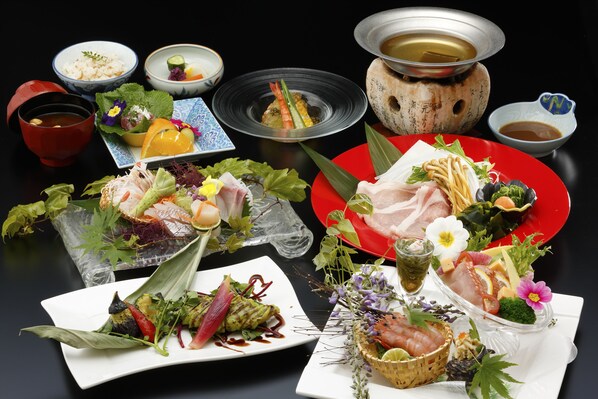 Diversos pratos e um conjunto para fondue sobre a mesa.
