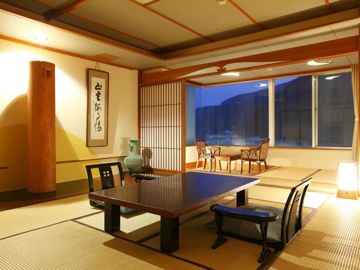 A traditional Japanese room with tatami flooring, a low table, and shoji screens.