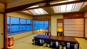 A traditional Japanese-style room with tatami flooring, a low table, and sliding doors. - Tokiwaya (Numazu)
