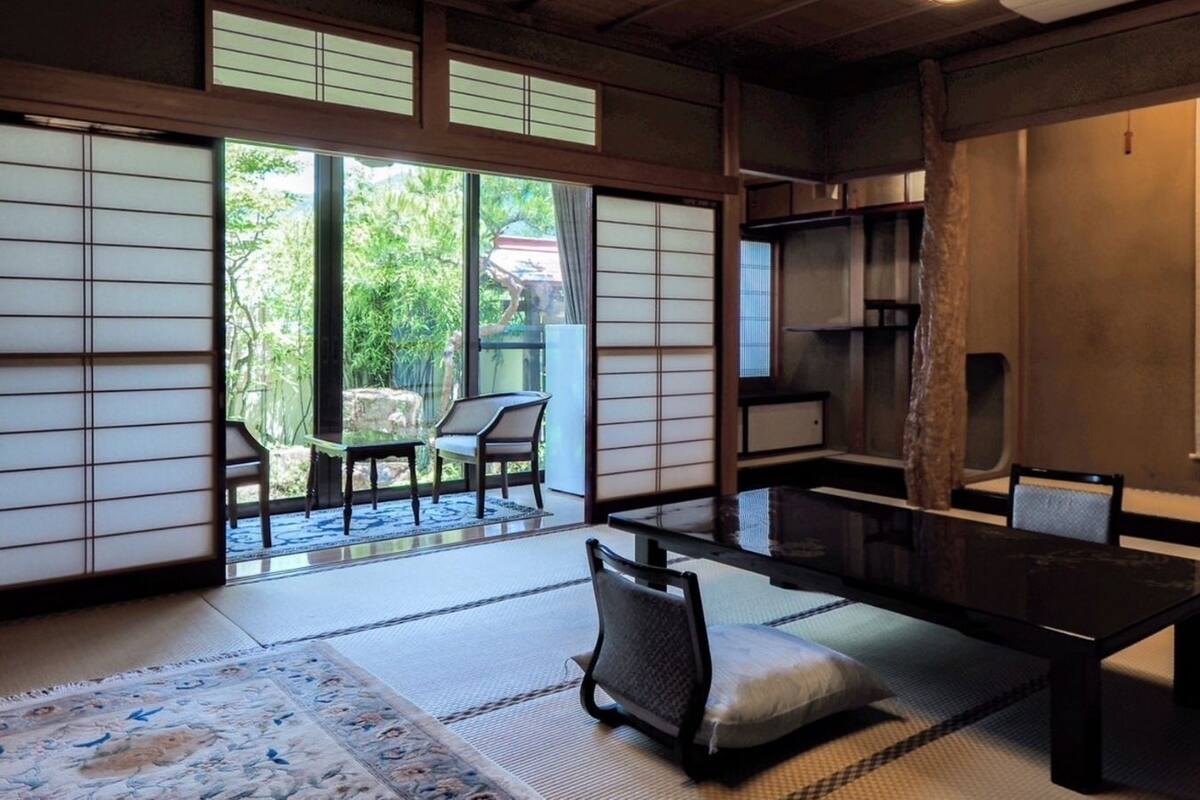 Une pièce de style japonais traditionnel, avec un sol recouvert de tatamis, une table basse et des portes coulissantes.