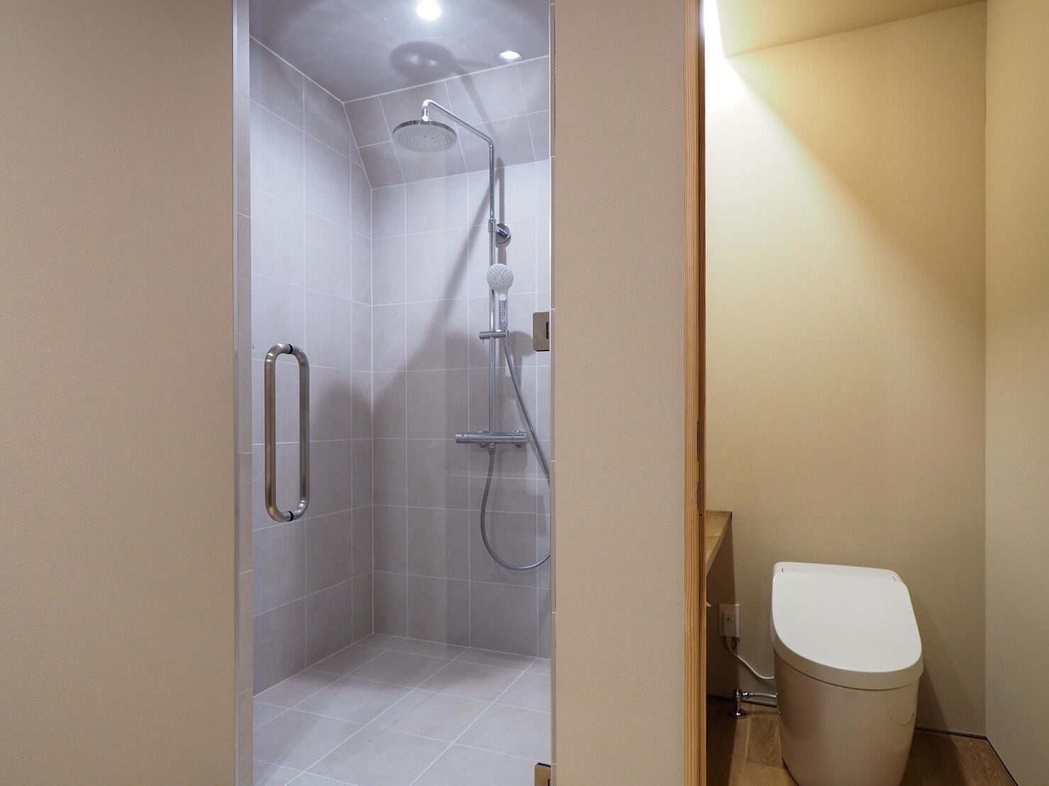 Un baño con ducha, inodoro y barandilla.