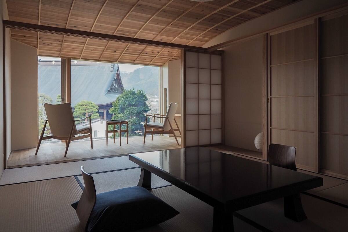 Une pièce de style japonais traditionnel, avec un sol recouvert de tatamis, une table basse et des portes coulissantes.