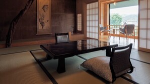 Ein traditioneller japanischer Raum mit Tatami-Boden, einem niedrigen Tisch und Shoji-Bildschirmen.