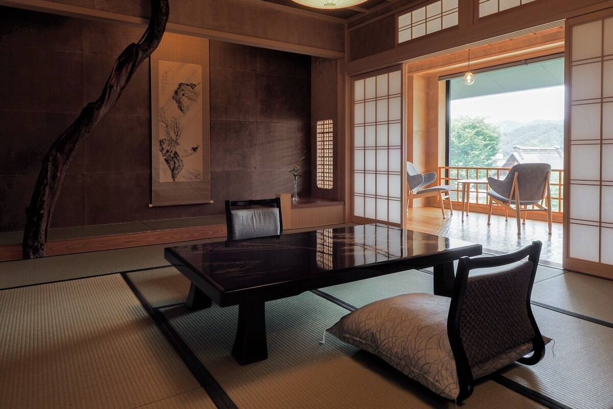 Une pièce de style japonais traditionnel, avec un sol recouvert de tatamis, une table basse et des paravents en papier de riz (shoji).