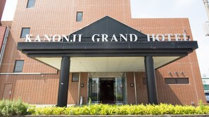 The exterior of the Kanonji Grand Hotel with a prominent entrance and a tiled facade. - Kanonji Grand Hotel (Kanonji)