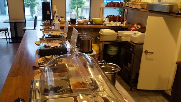 A buffet area with various food options, a coffee machine, and a refrigerator. - Hotel Matsuyama Hills (Matsuyama)