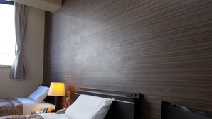 A hotel room with a bed, a bedside table with a lamp, and a flat-screen TV mounted on the wall. - Hotel Matsuyama Hills (Matsuyama)