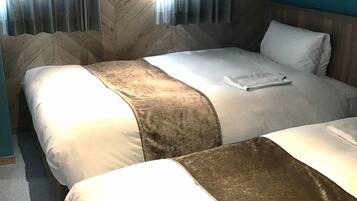 A hotel room with two beds, a wooden headboard, and a window with curtains.