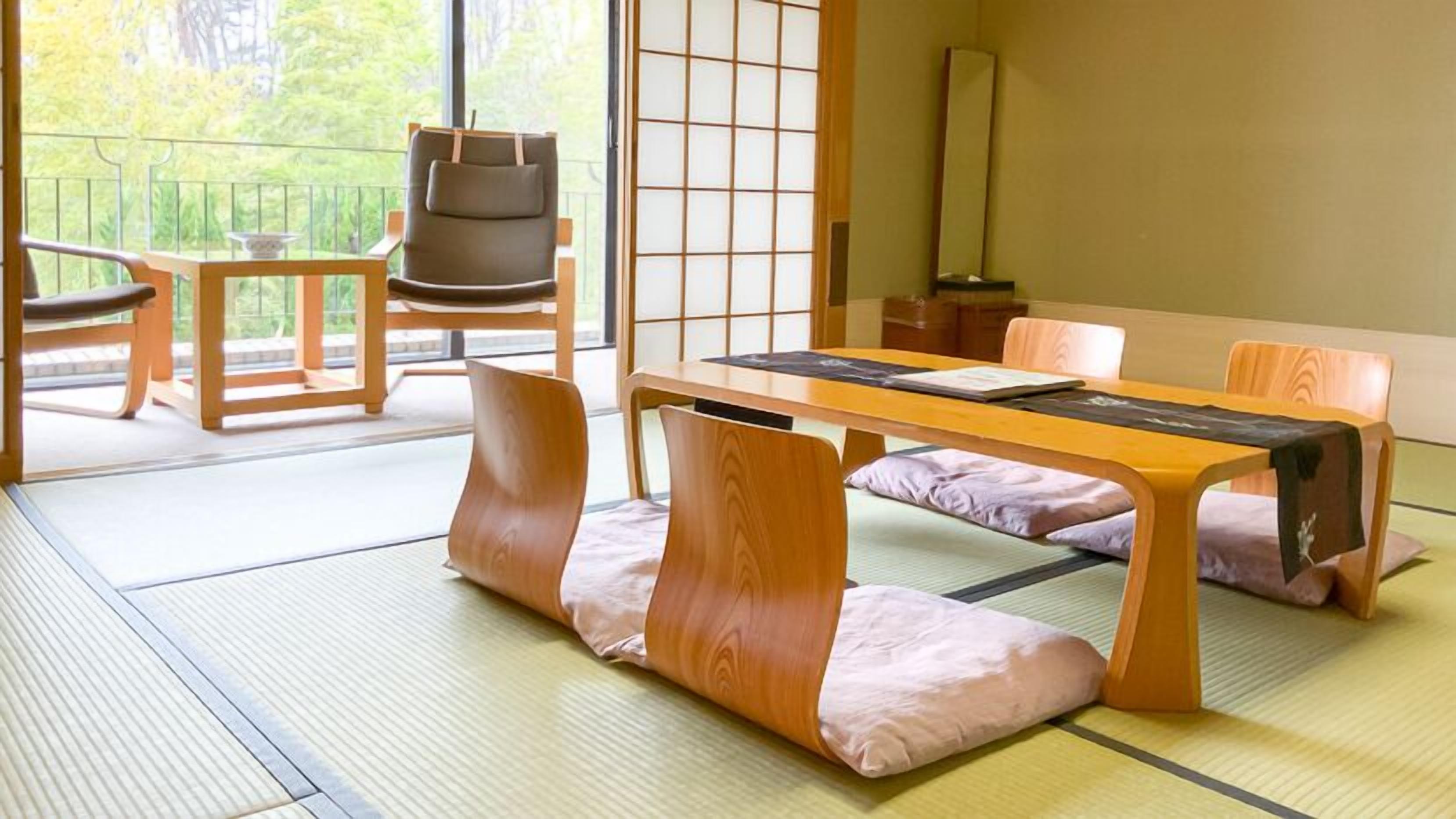 Ein traditioneller japanischer Raum mit Tatami-Bodenbelag, einem niedrigen Tisch und Holzmöbeln.