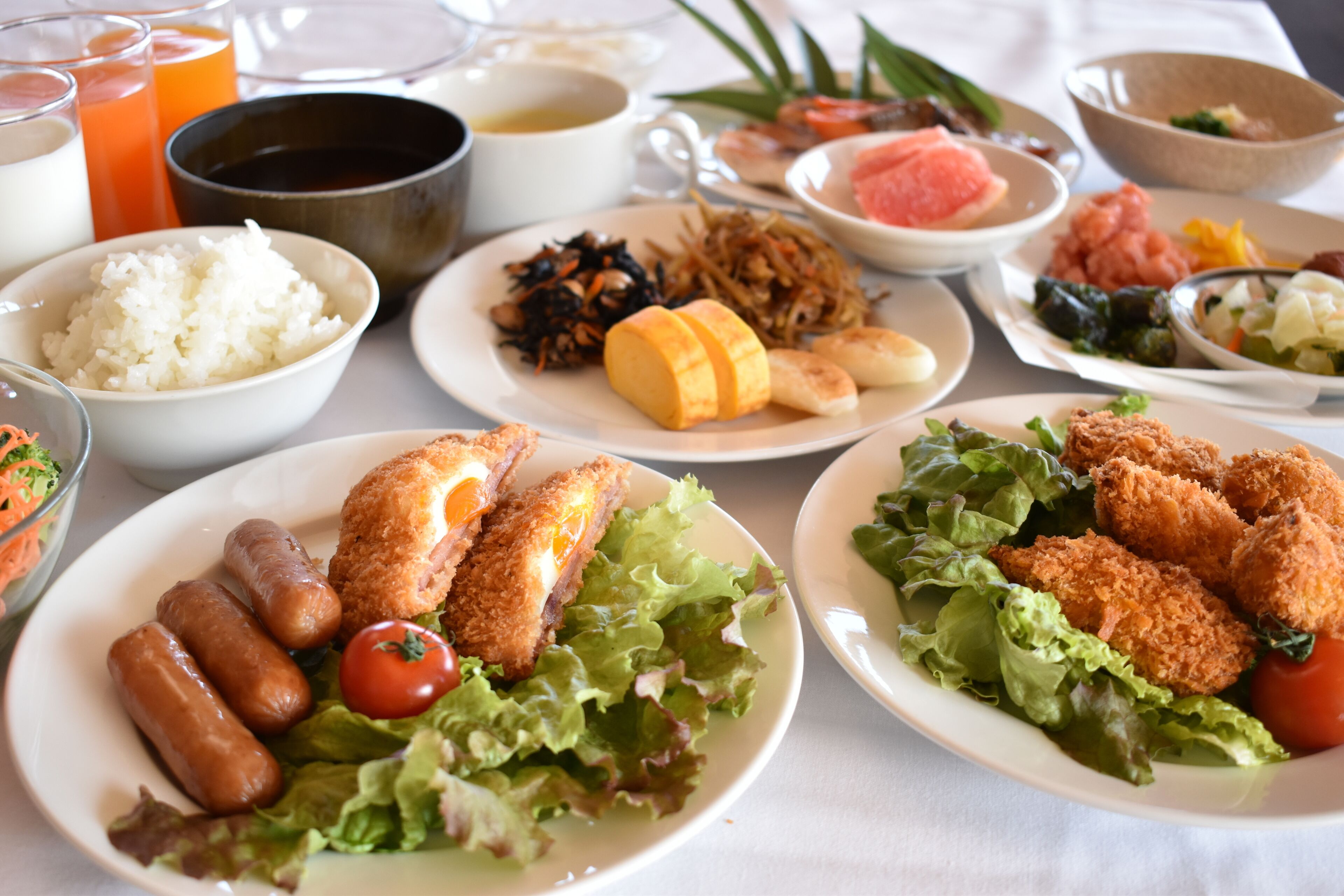 A table with various dishes including fried chicken, rice, and vegetables.