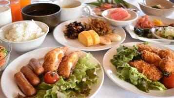 A table with various dishes including fried chicken, rice, and vegetables.