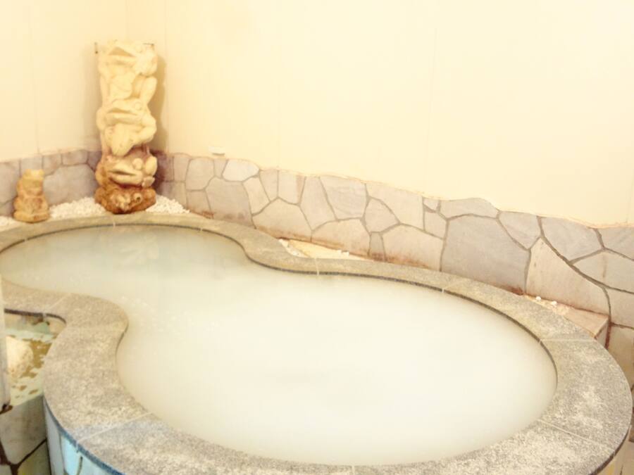 Un bain à remous bordé de pierres et agrémenté de deux statues décoratives.