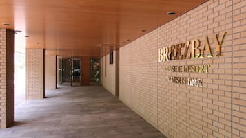 Um corredor com parede de tijolos e placa indicando BreezeBay Sensitive Resort.