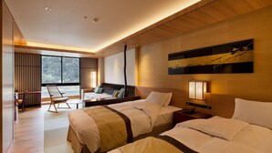 A modern hotel room with two beds, a seating area, and a large window offering a view of the outdoors. - Gifu Grand Hotel (Gifu)