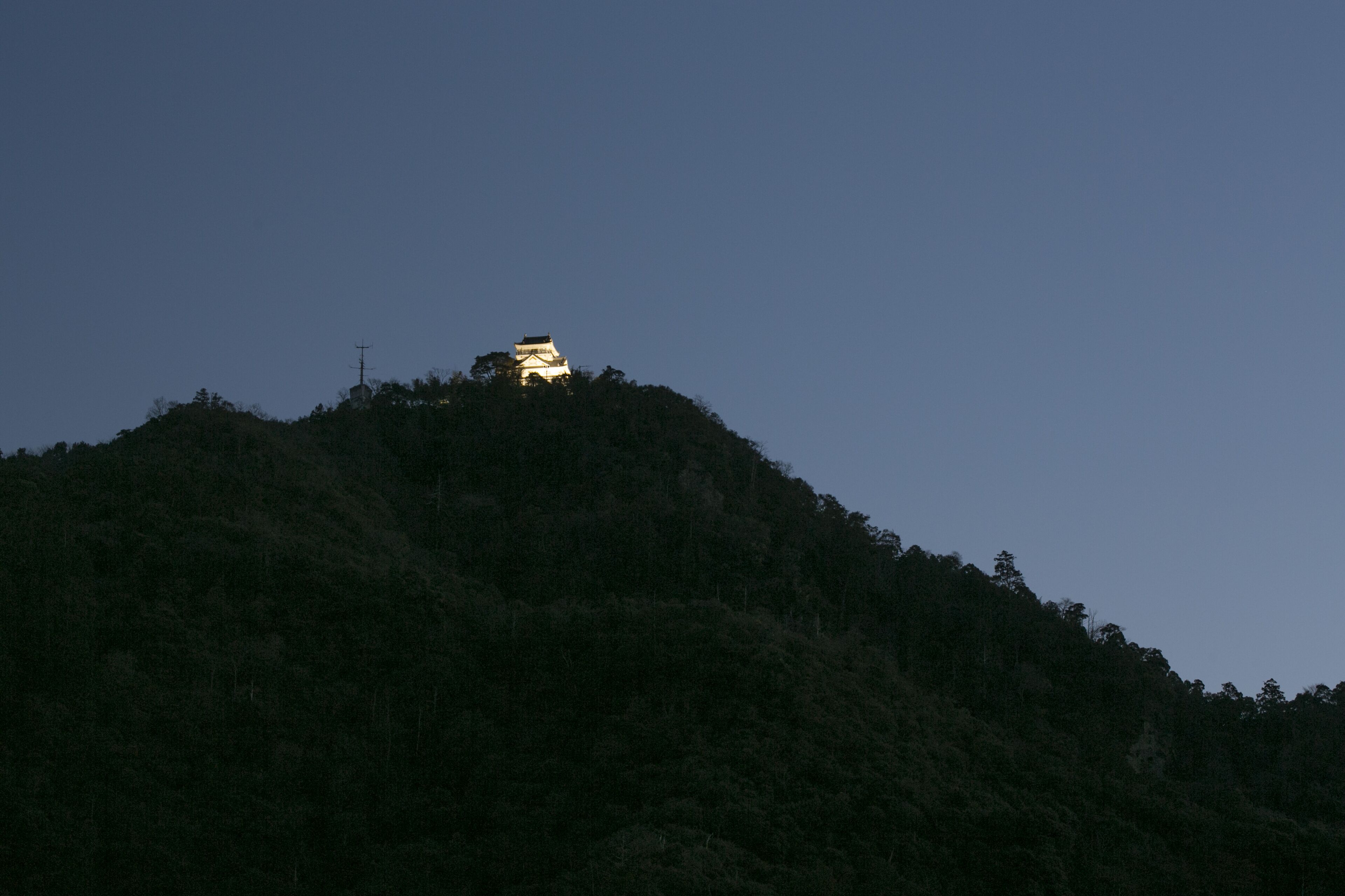 Un bâtiment situé sur une colline, sous un ciel dégagé.