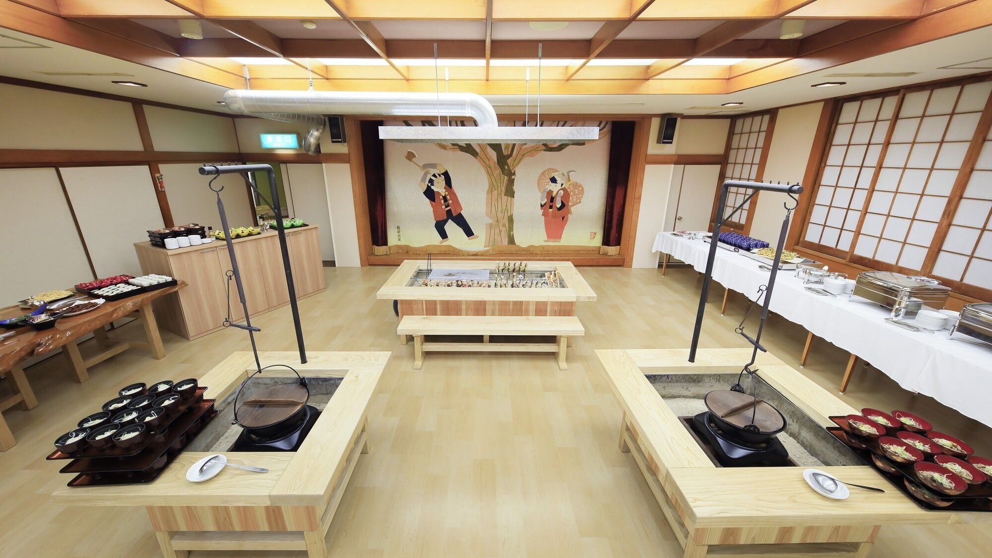 A room with a central table, two side tables with trays, a painting, and a traditional Japanese sliding door.