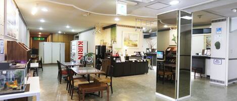 A spacious indoor area with a reception desk, seating arrangements, and a counter.