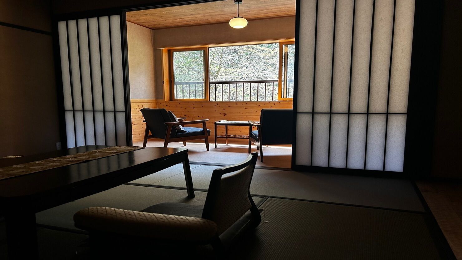 Una tradizionale stanza giapponese con pavimento in tatami, un tavolino e sedie.