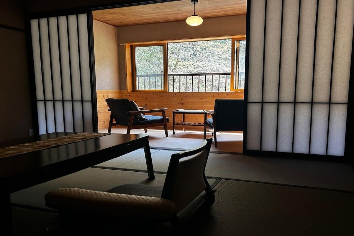 Ein traditioneller japanischer Raum mit Tatami-Bodenbelag, einem niedrigen Tisch und Stühlen.