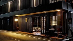 Un edificio moderno con techo plano, ventanas amplias y un balcón.