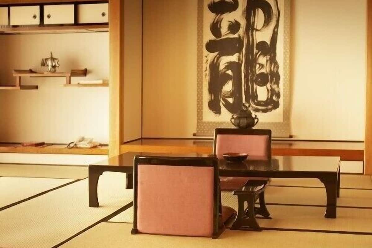 Una habitación japonesa tradicional con suelo de tatami, una mesa baja y sillas.