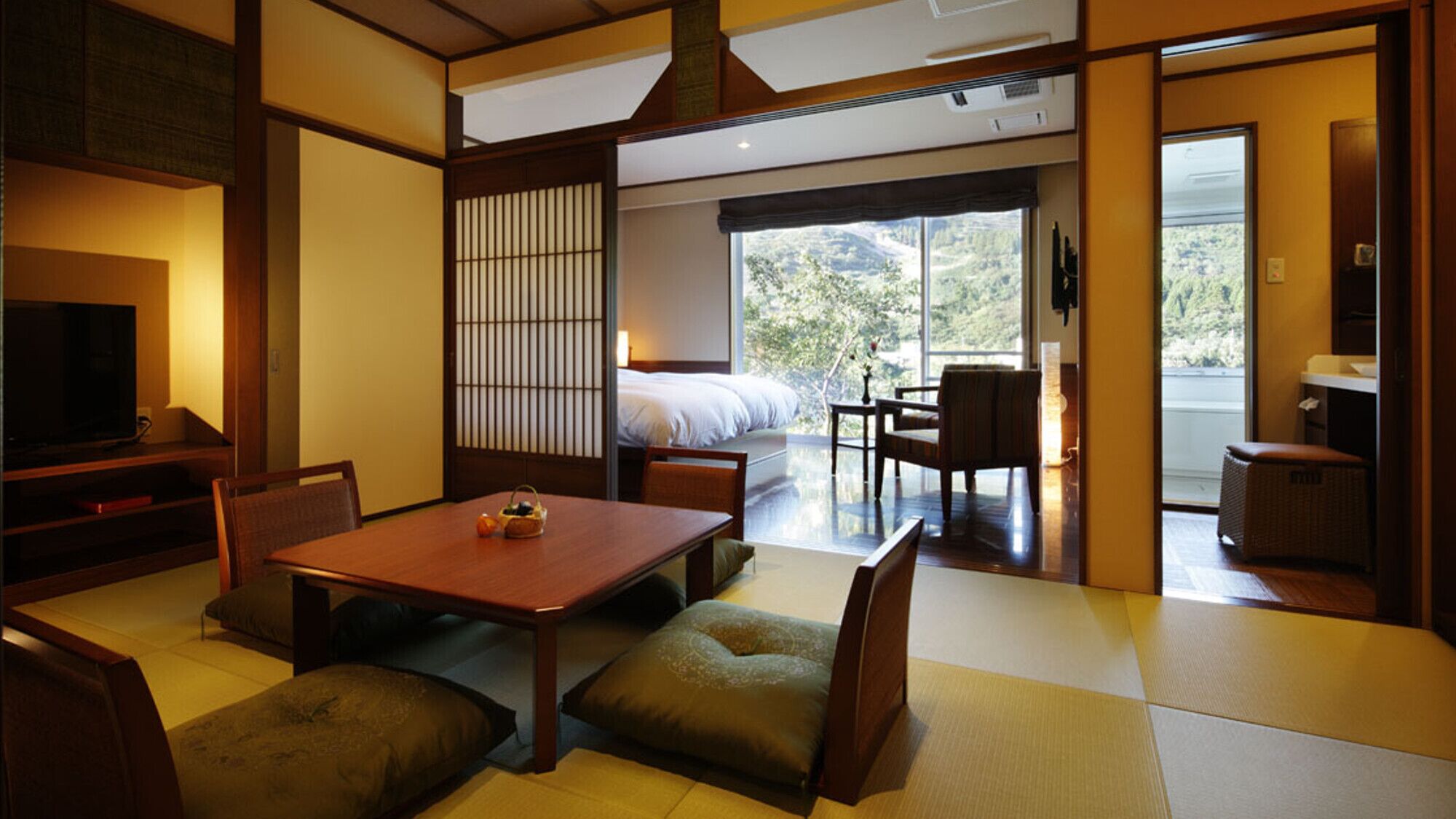 A traditional Japanese-style room with tatami flooring, a low table, and a futon bed.