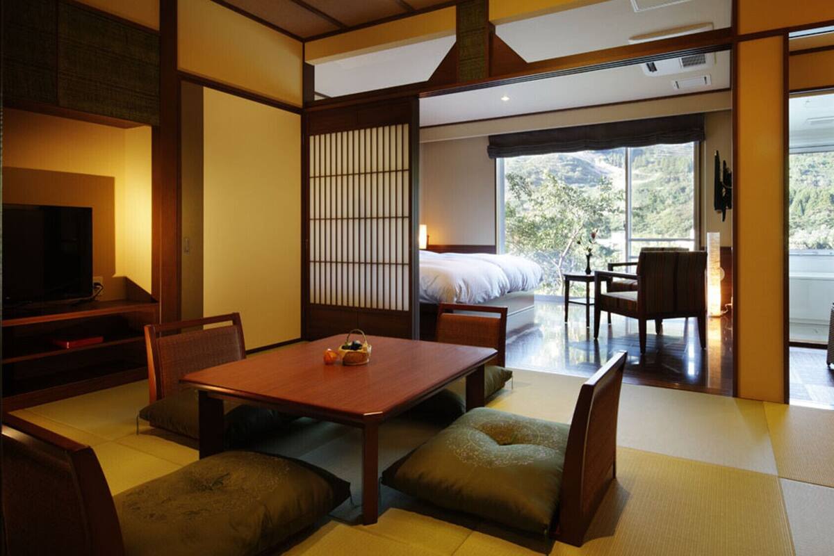 Una habitación tradicional japonesa con suelo de tatami, una mesa baja y un futón.