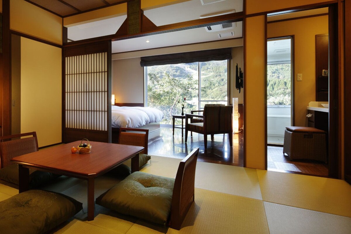 Una habitación tradicional japonesa con suelo de tatami, una mesa baja y un futón.