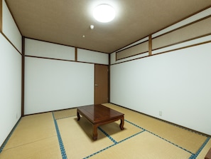 A room with tatami flooring, a wooden table, and a sliding door. - Tabist Sumiyoshiya Neo Usuzumi (Motosu)