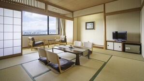 A traditional Japanese-style room with tatami flooring, a low table, and seating arrangements. - Chres (Kochi)