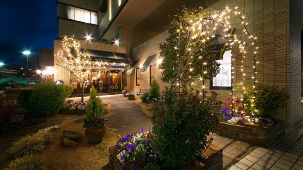 A restaurant with a modern exterior, outdoor seating, and decorative lighting. - Chres (Kochi)