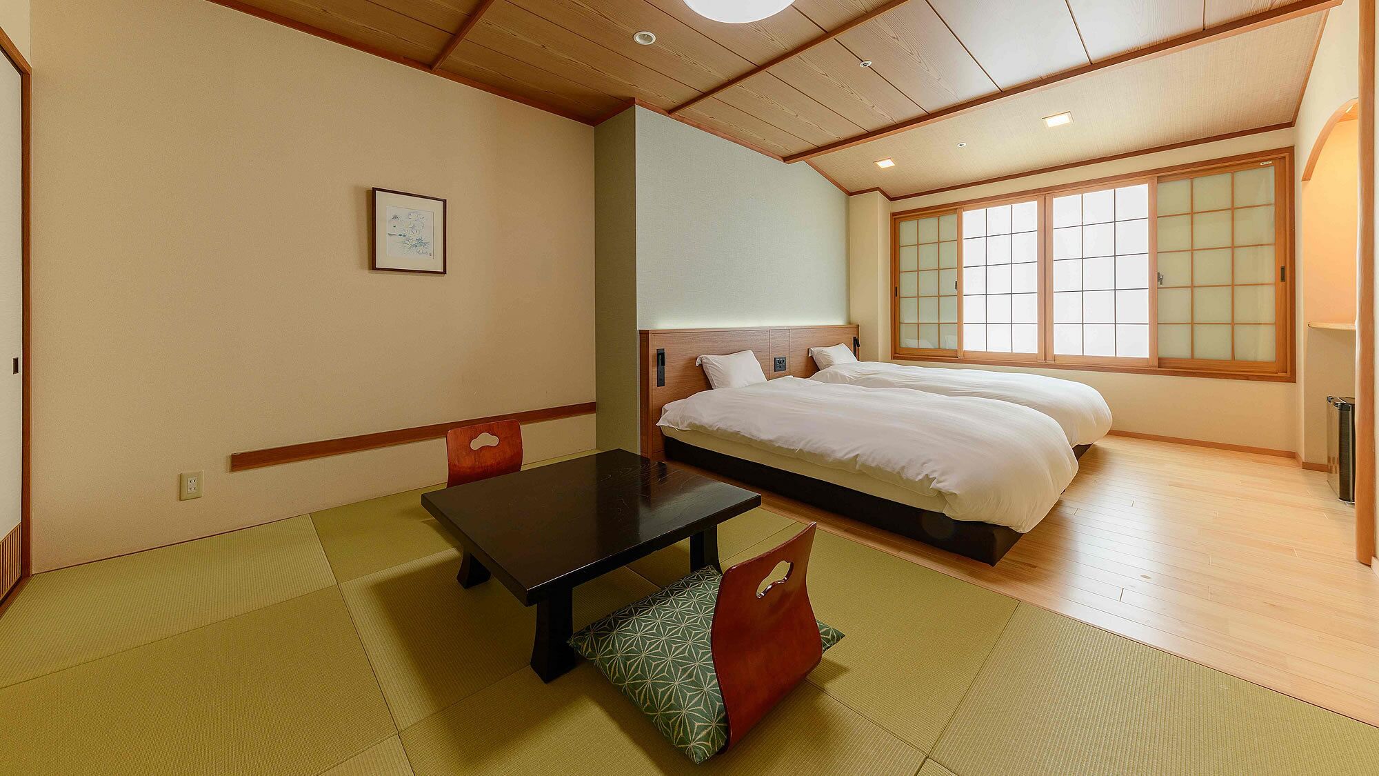 Une chambre d’hôtel avec un lit, une table et un futon.
