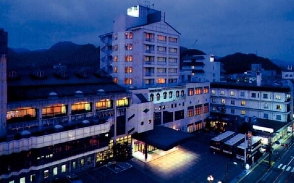A multi-story hotel with a central courtyard, surrounded by other buildings.